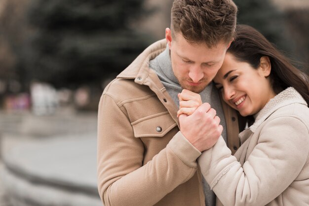 Foto grátis casal sorridente segurando as mãos do lado de fora