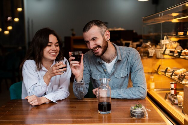 Casal sorridente segurando copos de café