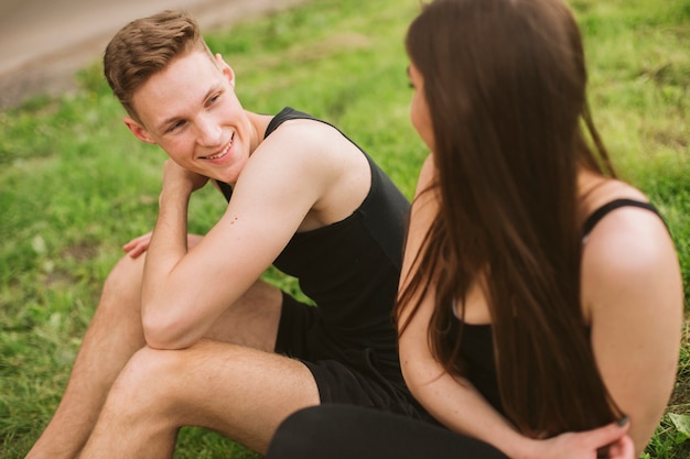 Casal sorridente sentado e olhando para o outro