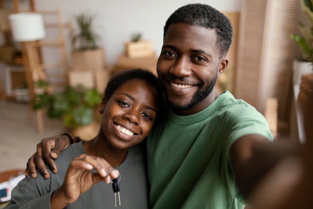 Casal sorridente tirando uma selfie em sua nova casa