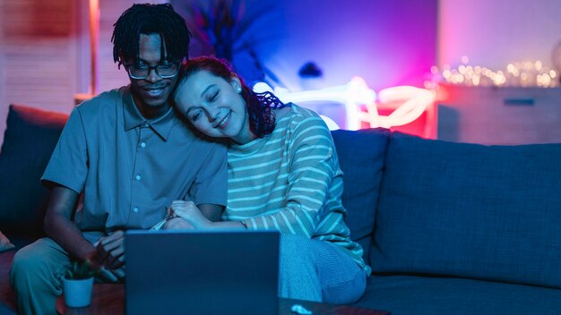 Foto grátis casal sorridente usando laptop em casa com espaço de cópia