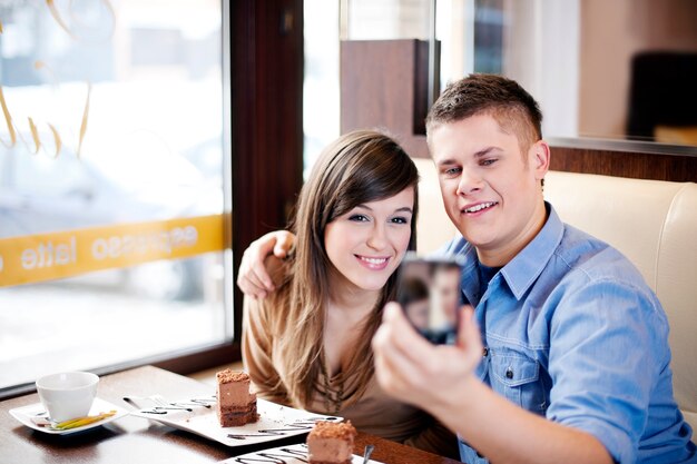 Casal tirando foto em um café