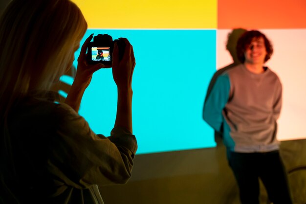 Casal tirando fotos à luz do projetor de filme