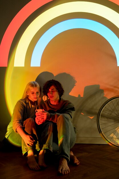 Casal tirando fotos à luz do projetor de filme