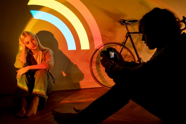 Casal tirando fotos à luz do projetor de filme