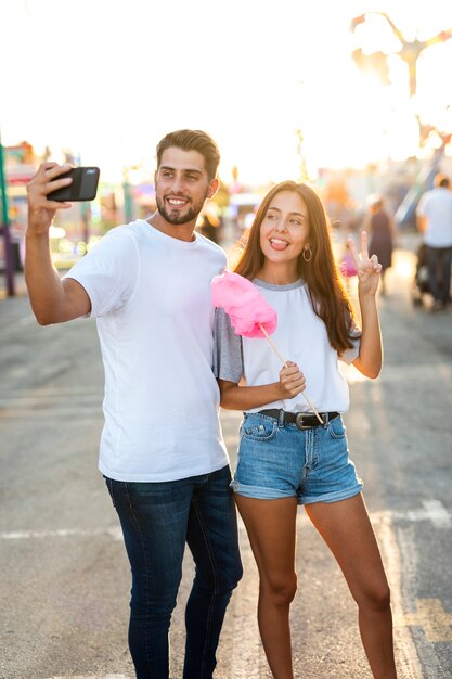 Casal tomando selfie com algodão doce