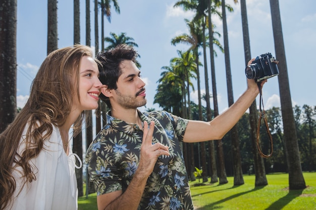 Casal tomando selfie com câmera vintage