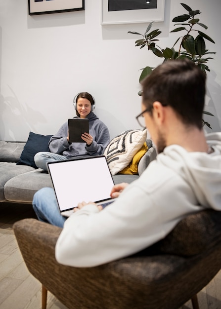 Casal trabalhando em casa em dispositivos