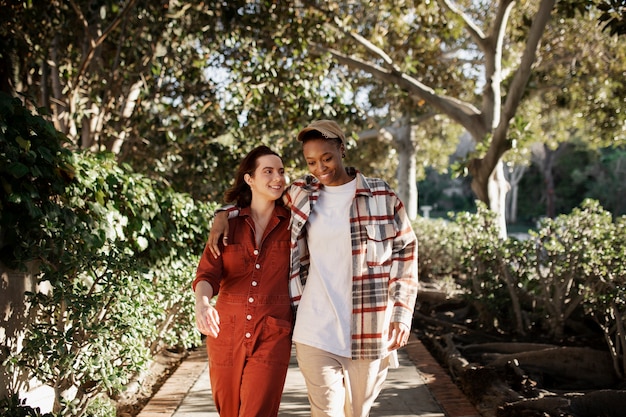 Casal trans andando e sorrindo nas ruas da cidade