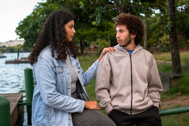 Casal triste sentado ao ar livre