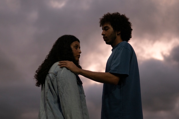 Foto grátis casal triste sentado ao ar livre