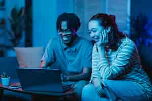 Foto grátis casal usando laptop enquanto está no sofá em casa