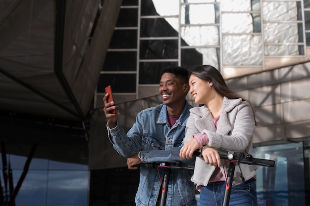 Foto grátis casal usando scooter elétrico para transporte