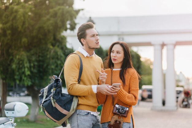 Casal viajando olhando ao redor com expressões de preocupação