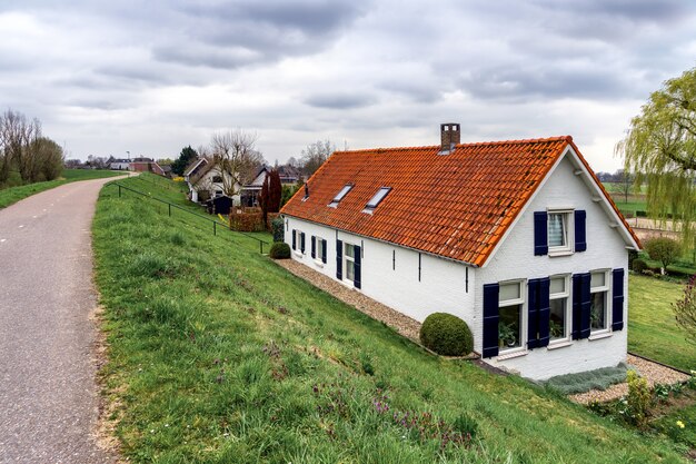 Casas atrás dos diques do rio perto de Sleeuwijk
