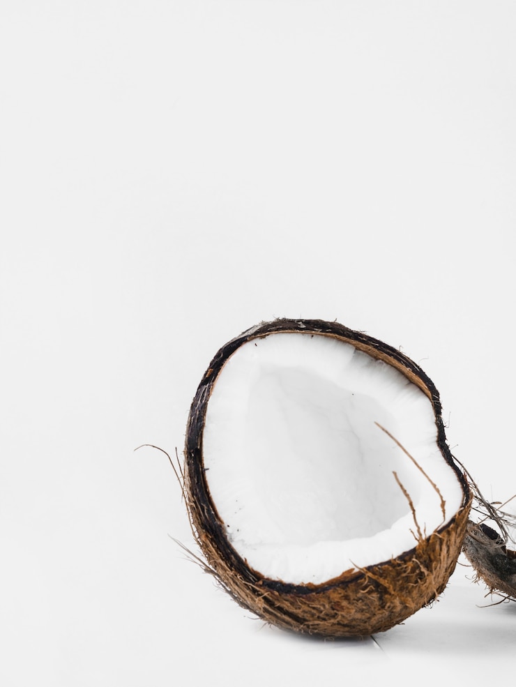 Foto grátis casca de coco cortados ao meio contra o fundo branco