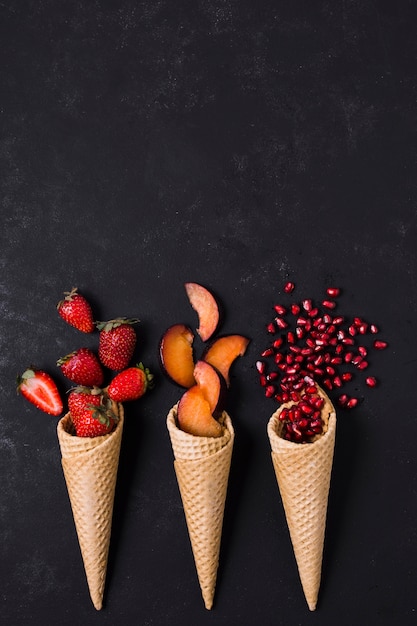 Foto grátis casquinhas de sorvete com frutas e espaço para texto