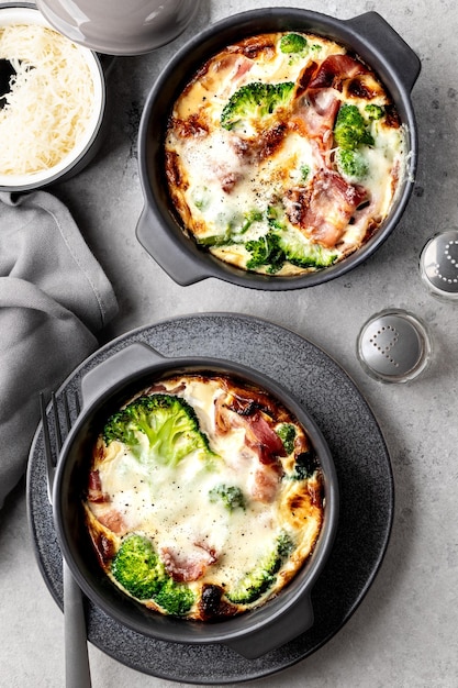 Casserole de brócolis em um prato de cerâmica cinza em um fundo de concreto