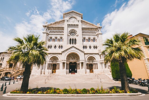 Catedral de São Nicolau cercada por vegetação sob a luz do sol durante o dia em Mônaco