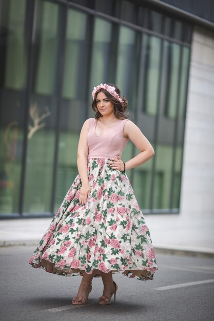 Caucasiano em frente a um edifício moderno em um vestido rosa e faixa de cabelo