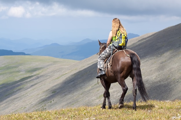 Foto grátis cavaleiro com mochila a cavalo