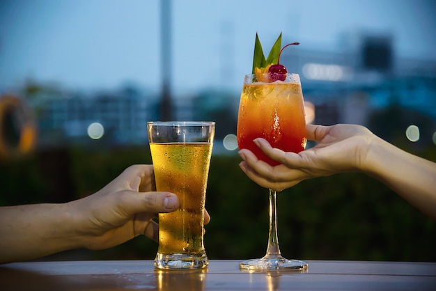 Celebração de casal no restaurante com cerveja refrigerante e mai tai ou mai tailandês