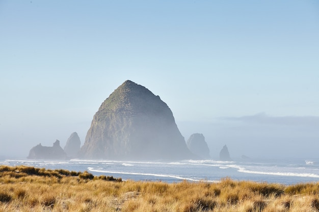 Cenário de Haystack Rock na névoa da manhã em Cannon Beach, Oregon