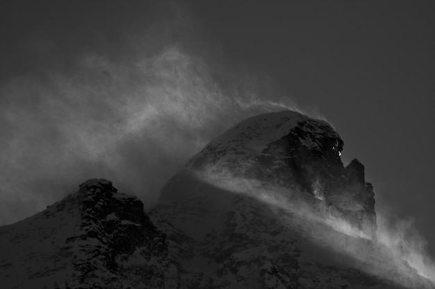 Cenário de tirar o fôlego das montanhas cobertas de neve sob um céu nublado panorâmico