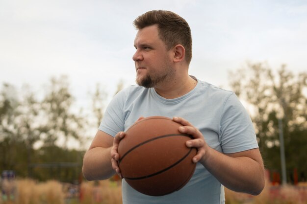 Cenas autênticas de homens de tamanho grande jogando basquete