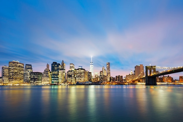 Centro de Nova York em Manhattan ao anoitecer com arranha-céus iluminados sobre o East River