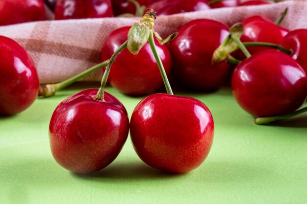 Cereja de vista frontal vermelho com uma toalha de cozinha em verde claro