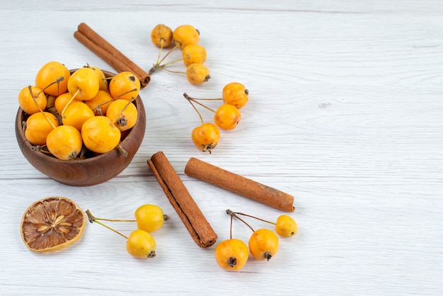 cerejas amarelas maduras e frescas junto com canela na luz