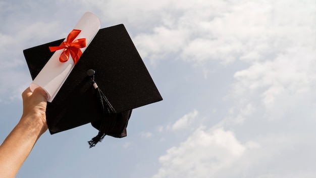 Certificado com fita e laço e chapéu de formatura