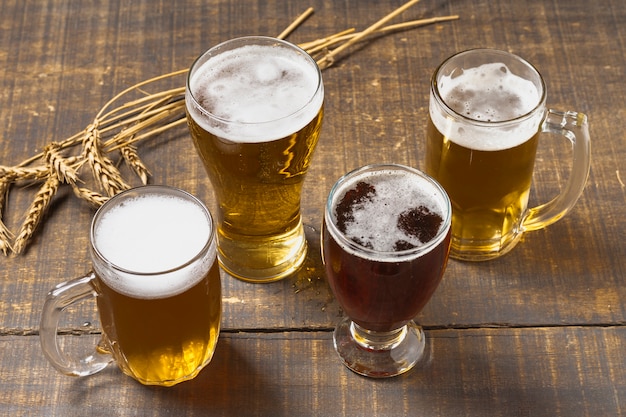 Foto grátis cerveja de alto ângulo em copos e cerveja com espuma