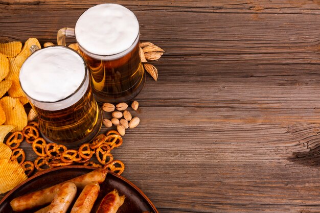 Cerveja de close-up com lanches na mesa de madeira