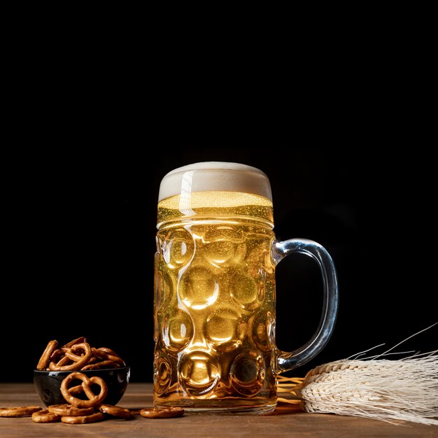 Cerveja loira close-up em uma mesa com pretzels