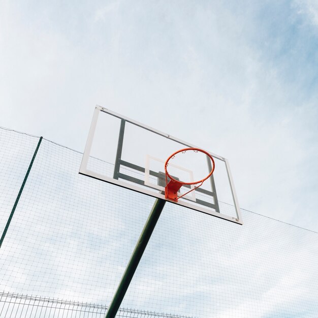 Cesta de basquete e net na vedação com vista para o céu