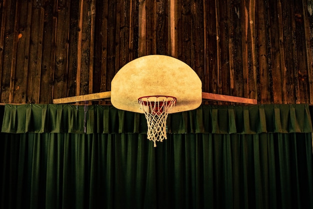 Cesta de basquete marrom e vermelho perto de cortinas verdes