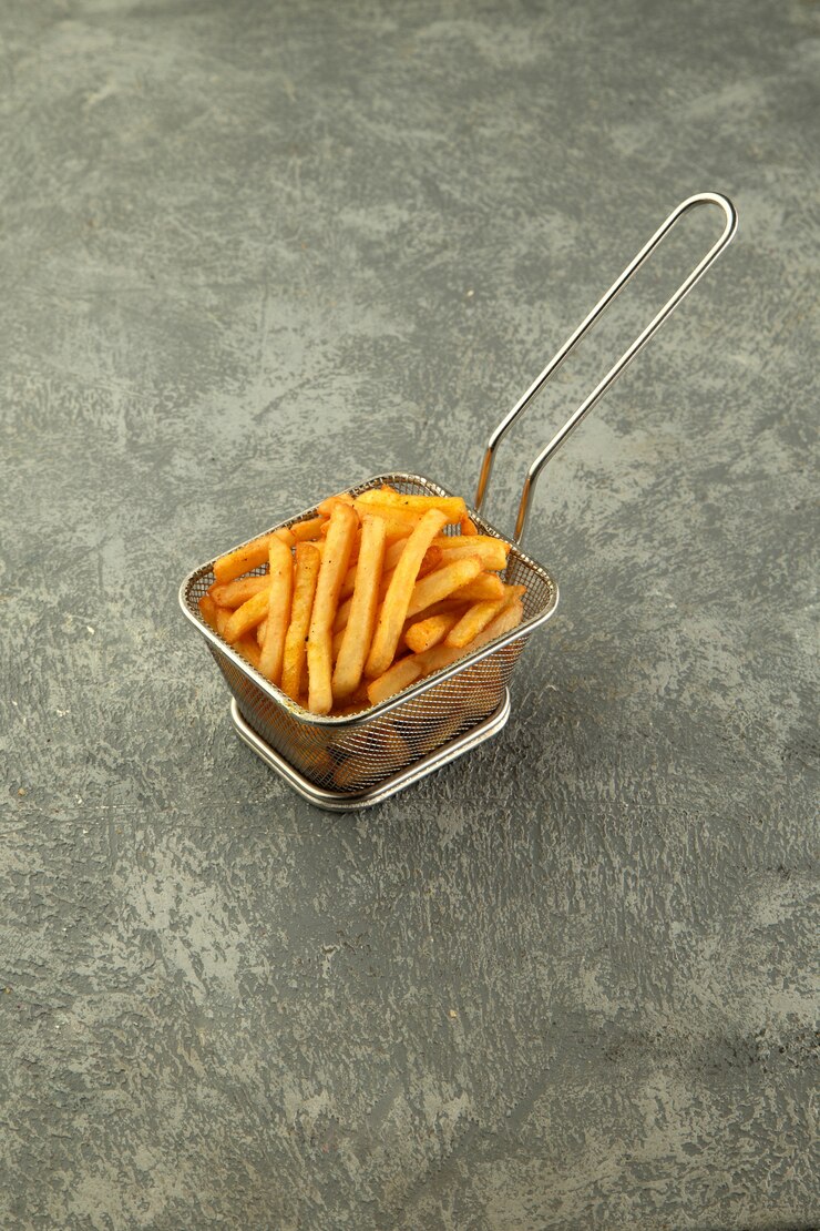 Foto grátis cesto de aço de batatas fritas em fundo cinza simples