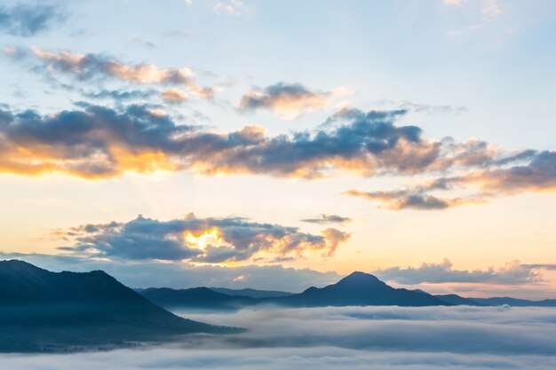 Céu com raios de sol e montanhas