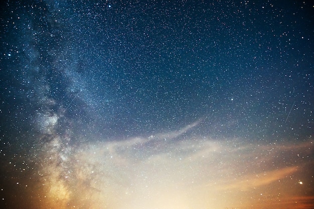 Céu noturno vibrante com estrelas, nebulosa e galáxia.