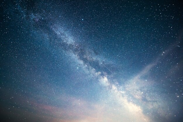 Céu noturno vibrante com estrelas, nebulosa e galáxia.