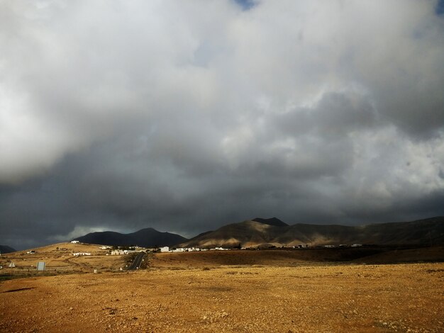 Céu nublado sombrio e uma terra arenosa de Fuerteventura, Espanha.