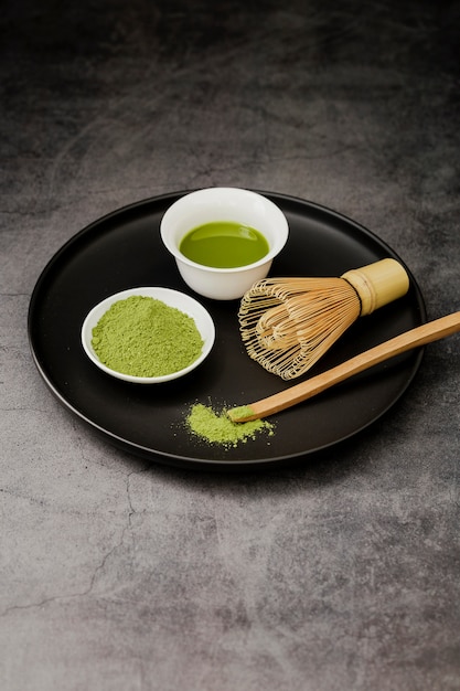 Chá Matcha na xícara e batedor de bambu no prato