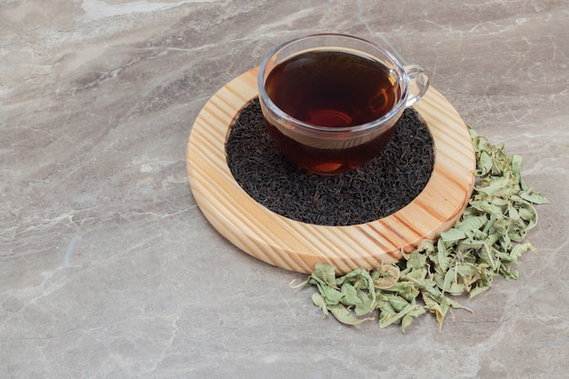 Foto grátis chá quente com folhas secas na placa de madeira.