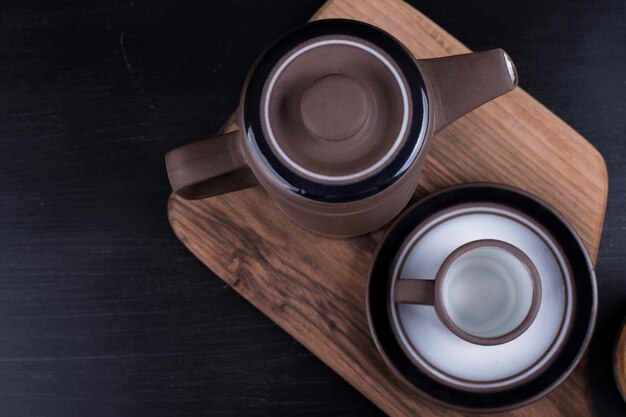 Chaleira de café com uma xícara em uma bandeja de madeira.