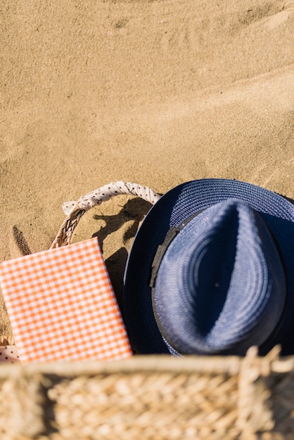 Chapéu, cesta e diário na areia