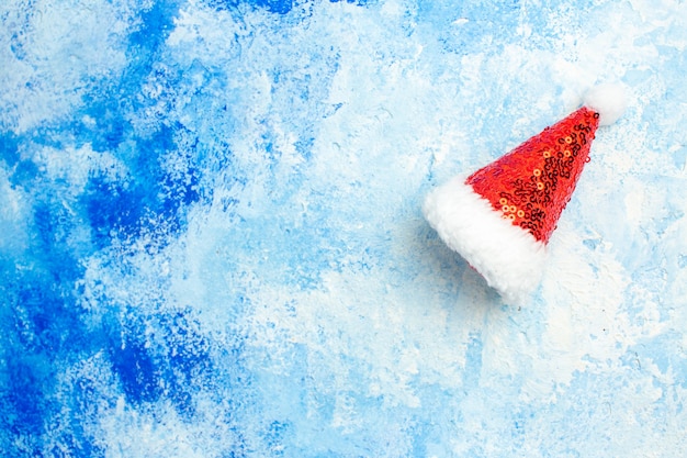 Foto grátis chapéu de papai noel com vista de cima na mesa azul com espaço livre