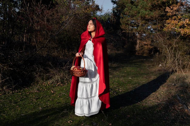 Foto grátis chapeuzinho vermelho com cesto de madeira com guloseimas