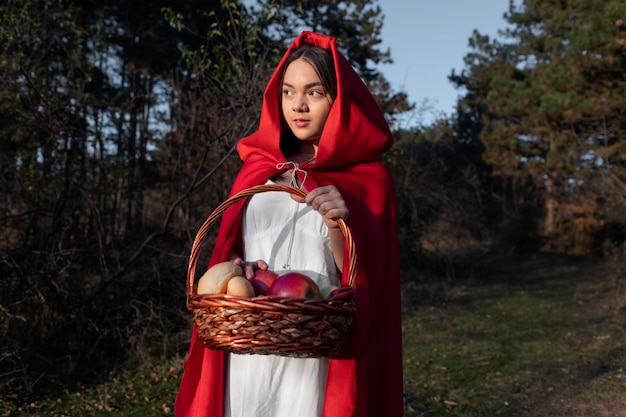 Foto grátis chapeuzinho vermelho com cesto de madeira com guloseimas